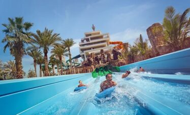 A group sliding down a multi-lane water slide at Atlantis Waterpark Dubai