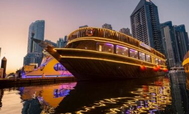 Luxury dhow cruise sailing past modern high-rise buildings in Dubai Marina
