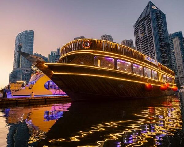 Luxury dhow cruise sailing past modern high-rise buildings in Dubai Marina